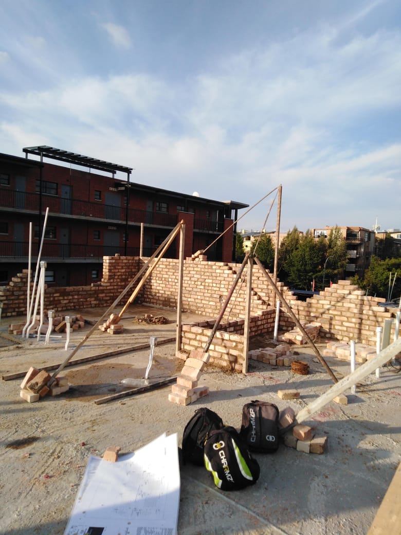 Brick walls of a complex unit under construction with temporary bracing