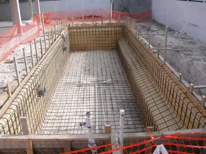Rectangular swimming pool under construction with steel reinforcement cage and formwork